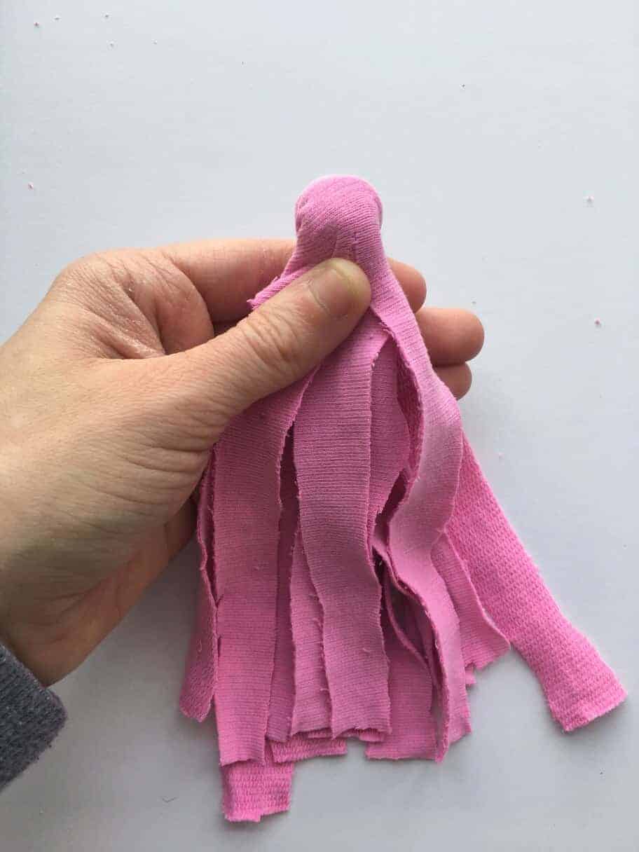 hand holding pink DIY fabric tassel