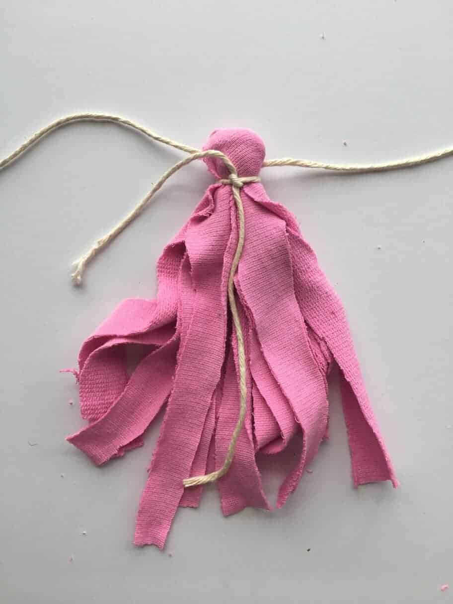 pink fabric tassel tied with cream baker's twine