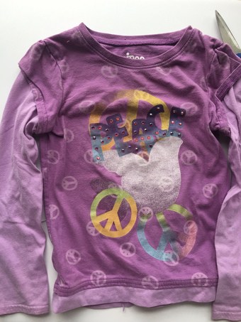 purple long sleeve child's shirt with peace signs on front