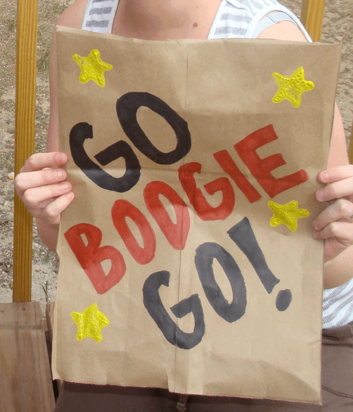 woman with a hand painted sign that says go boogie go!