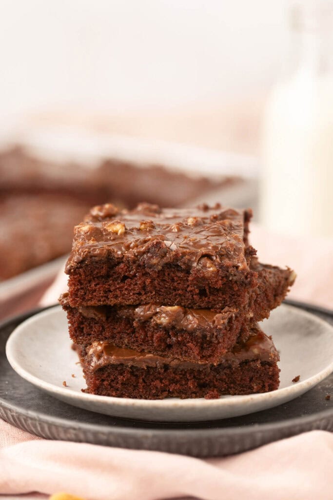 squares of Texas sheet cake stacked up on a plate
