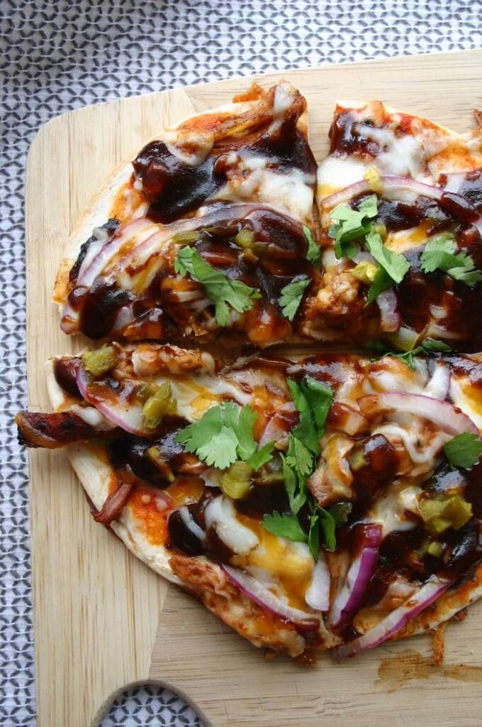 barbecue chicken tortilla pizza on a cutting board