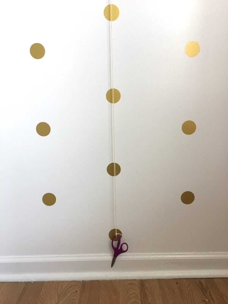 using a DIY plumb bob to apply wall stickers in straight rows