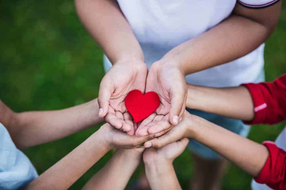 kids hands holding a paper heart