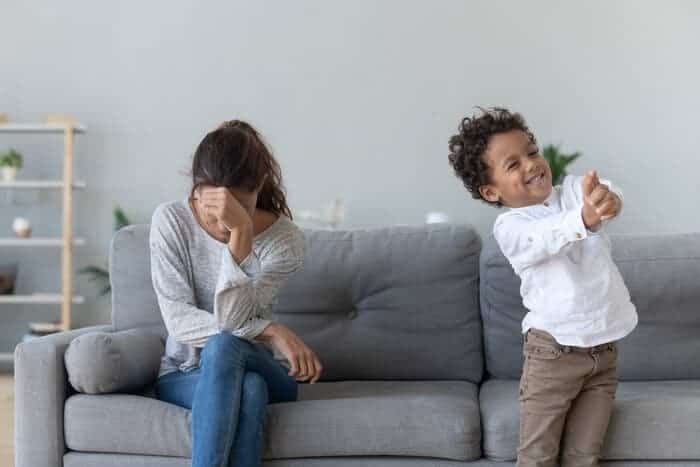 Overwhelmed Mom sitting on a couch 