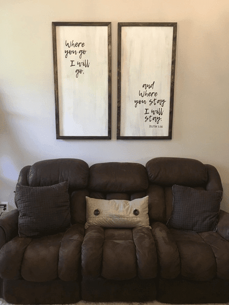 DIY wood signs hanging on a tan wall above a brown couch
