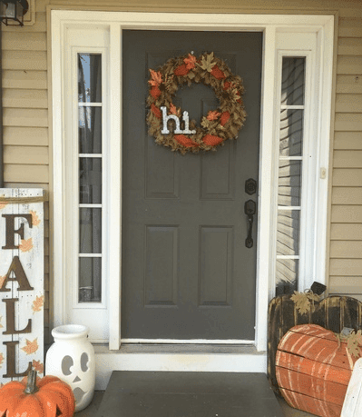 front porch decorated for fall with a burlap fall wreath and a fall sign