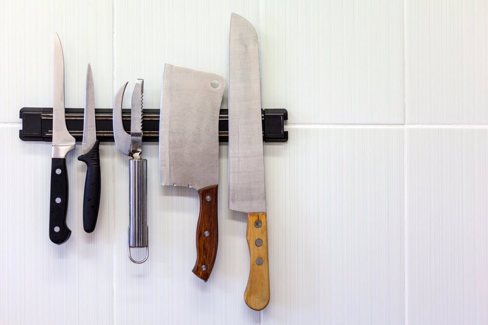 knives hanging on a magnetic strip in a kitchen