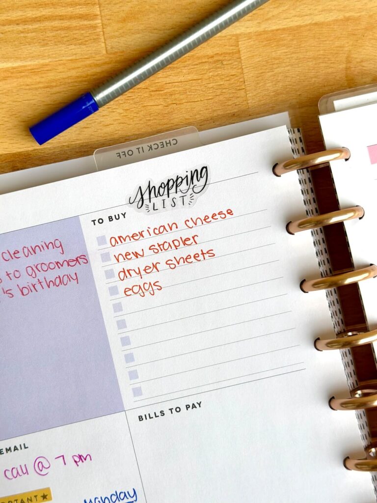 shopping list written in a planner with colorful pens