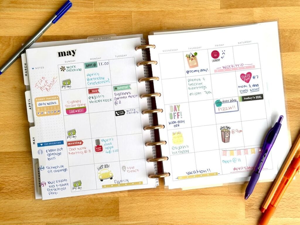 a Happy planner with important dates written on the monthly calendar pages with stickers and colorful pens