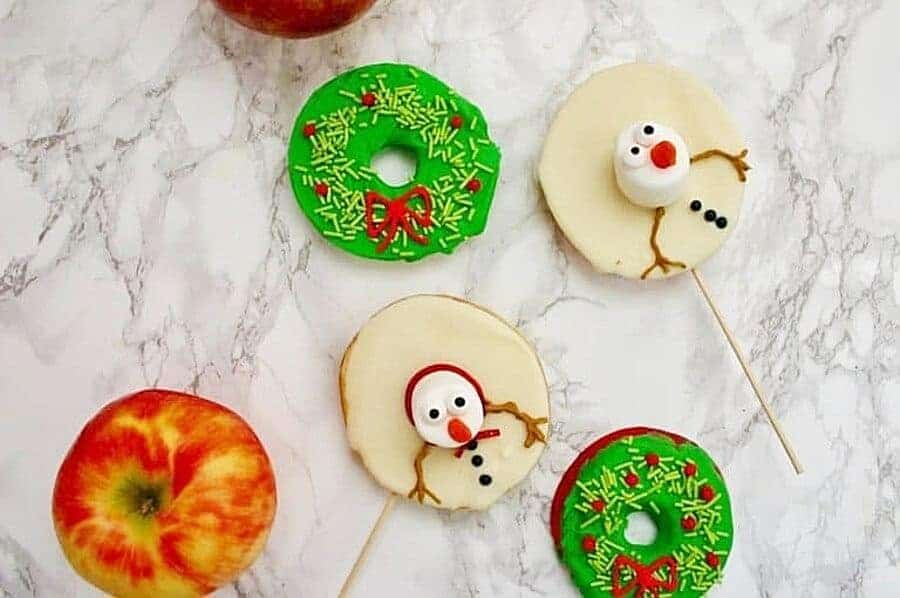 chocolate dipped apple slices decorated like snowmen and wreaths