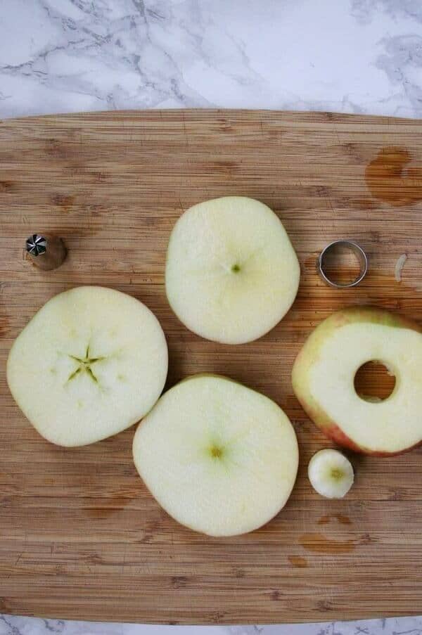 sliced apples on a cutting board being cored