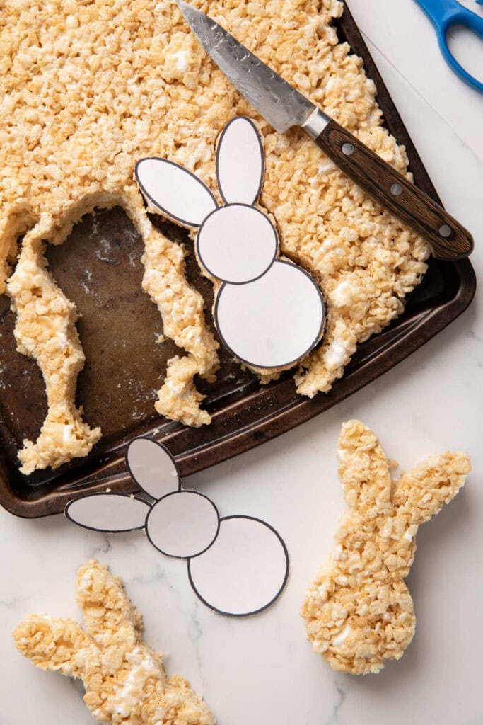 cutting out bunny Rice Krispies treats using a paring knife and a bunny paper template