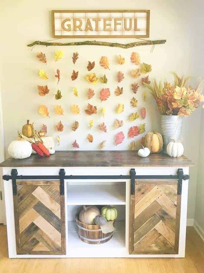 DIY fall leaf wall decor hanging above a buffet table