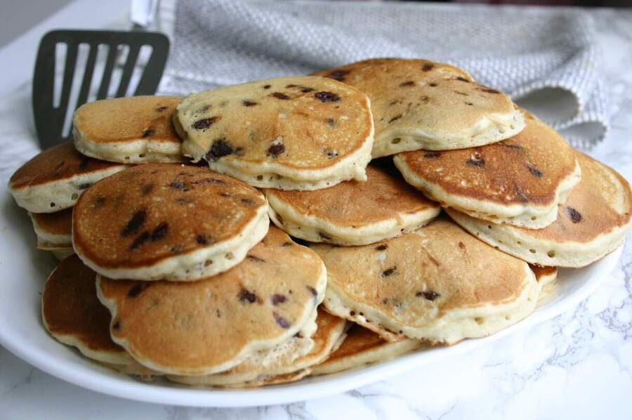 big batch of mini chocolate chip pancakes on a large plate