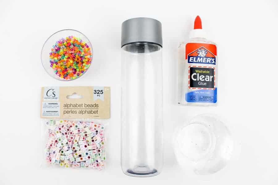 DIY sensory bottles supplies including water bottle, beads, glue, and water