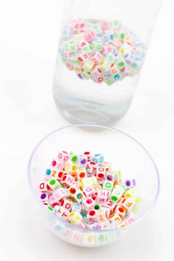 clear sensory bottle with glue and alphabet beads inside