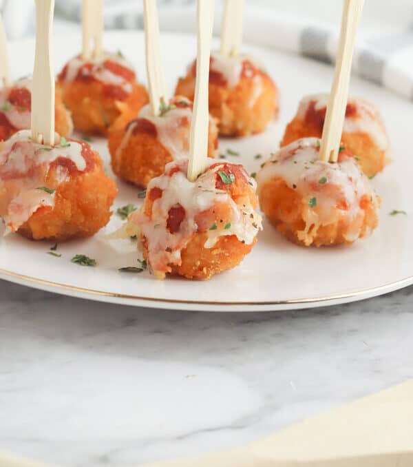 appetizer chicken parmesan bites with cocktail picks on a plate