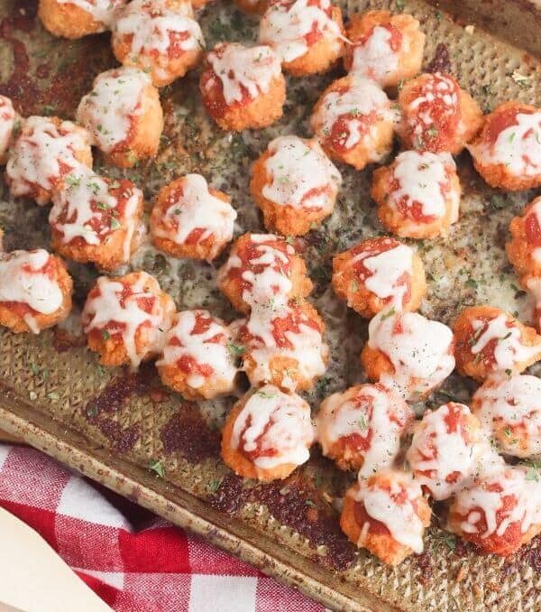 chicken parmesan bites on a baking sheet with a red and white towel