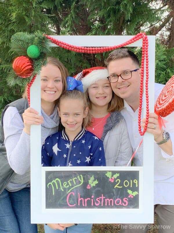 family posing for Christmas photo with a DIY polaroid photo frame 