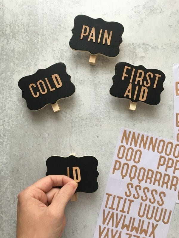 woman's hand applying letter stickers to DIY basket labels