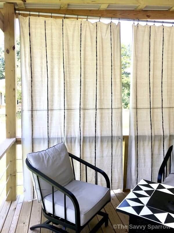 drop cloth curtains hanging on a deck with outdoor furniture