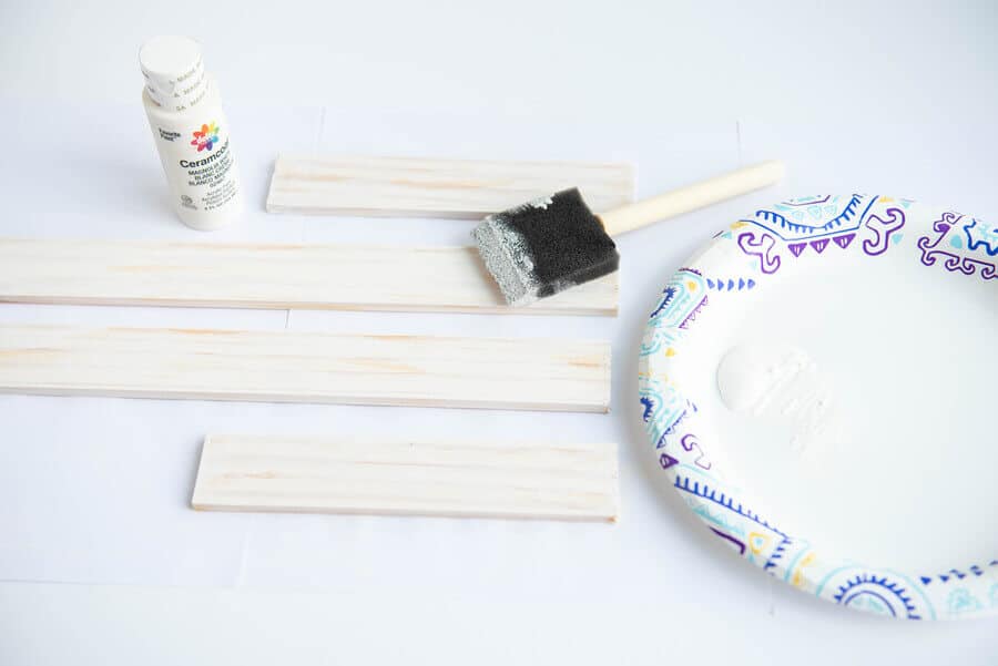 cut paint sticks with white paint and foam brush