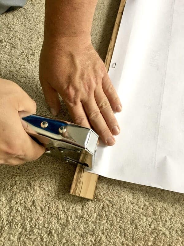 man's hands stapling DIY large wall calendar to board