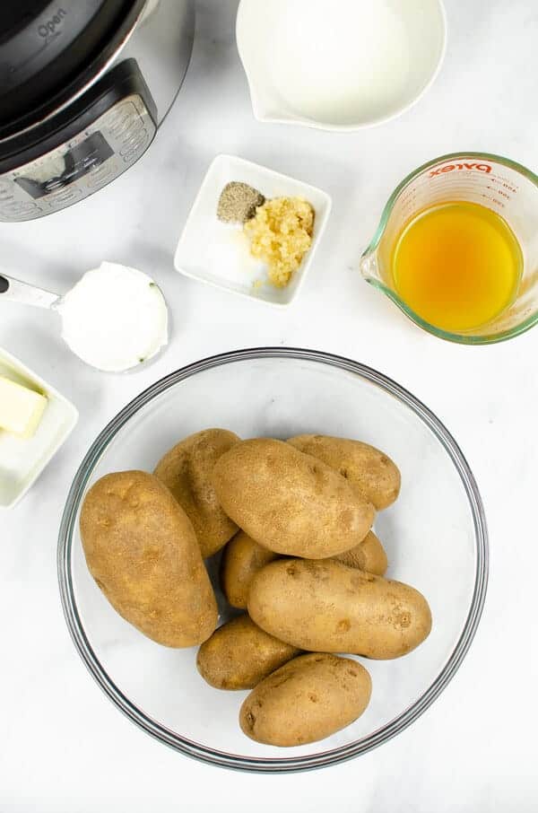 potatoes, chicken broth, sour cream, garlic, parsley and butter on a table