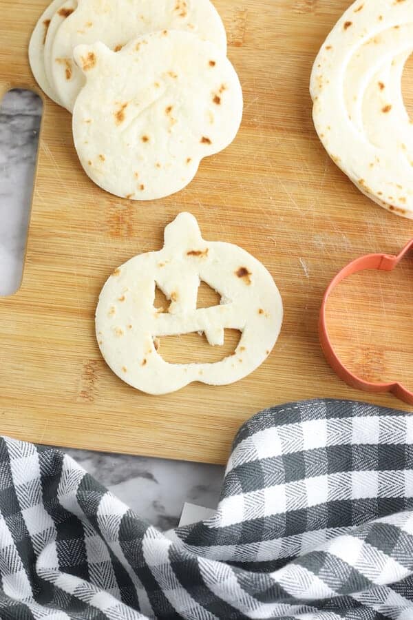 pumpkin shaped tortilla with jack-o-lantern face cut out