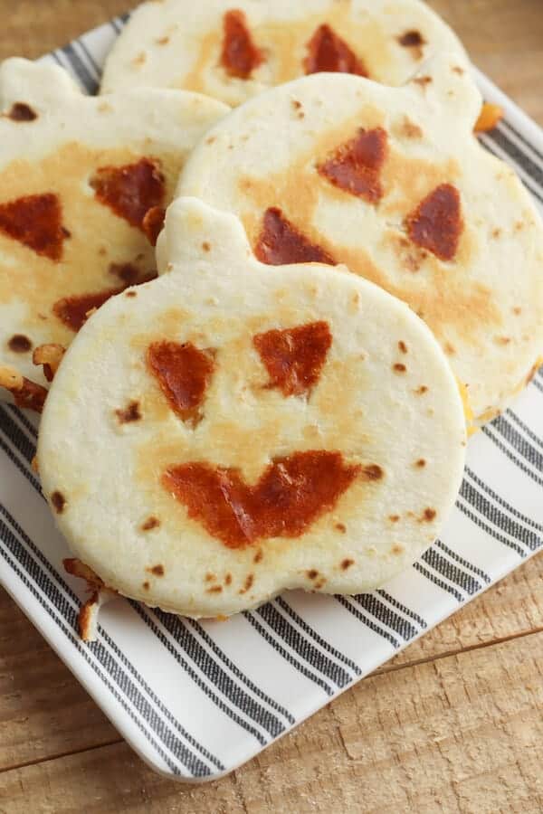 jack-o-lantern pumpkin shaped quesadillas on a plate