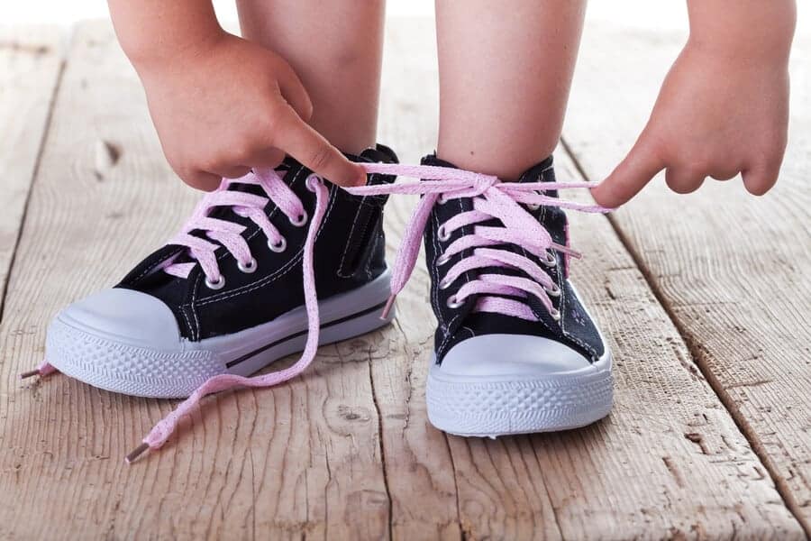 child tying her shoes