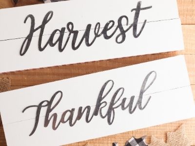 finished DIY fall signs that say Harvest and Thankful