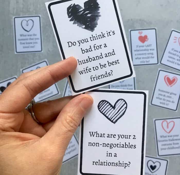 woman's hand holding 2 conversation cards