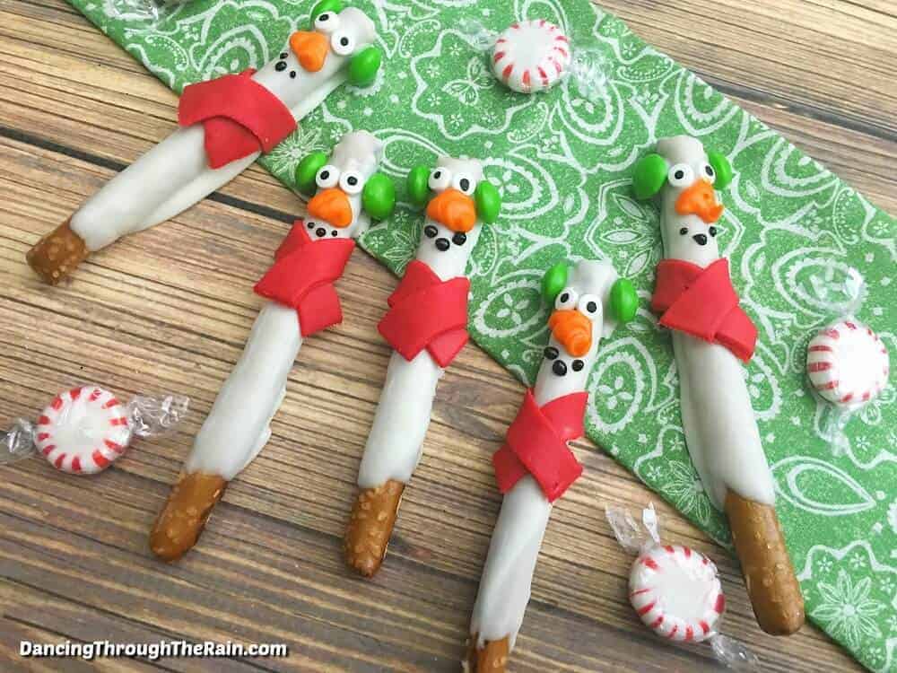 pretzel rods decorated like snowmen to give as DIY Christmas gifts