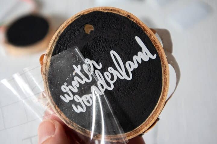 making DIY wood slice ornaments with vinyl lettering