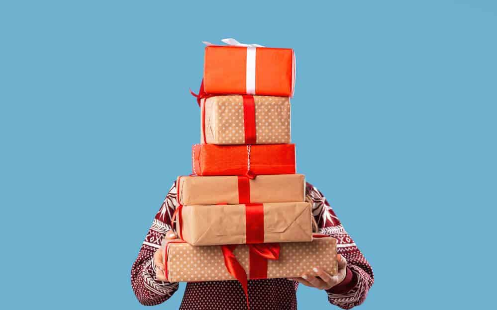 person holding a stack of Christmas presents