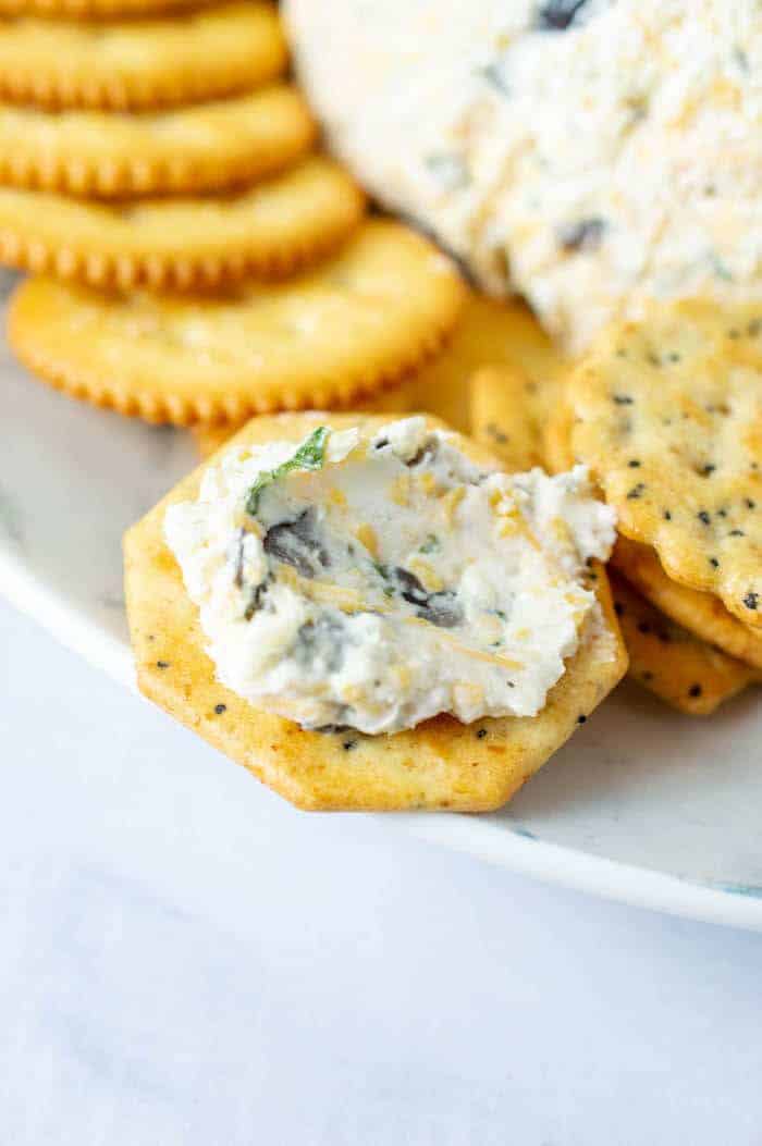 cracker with olive cheese spread on top