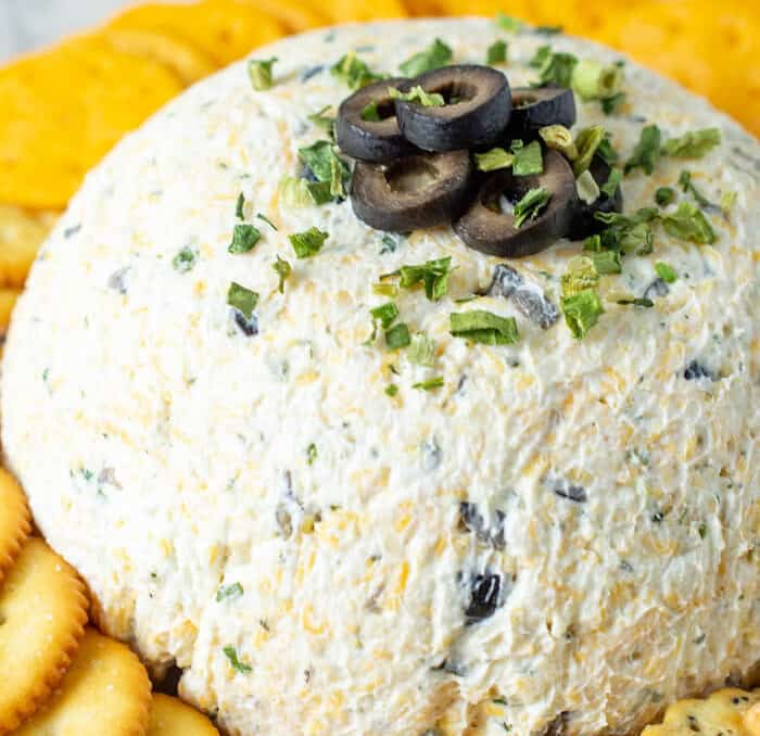 ranch olive cheeseball on a plate with crackers