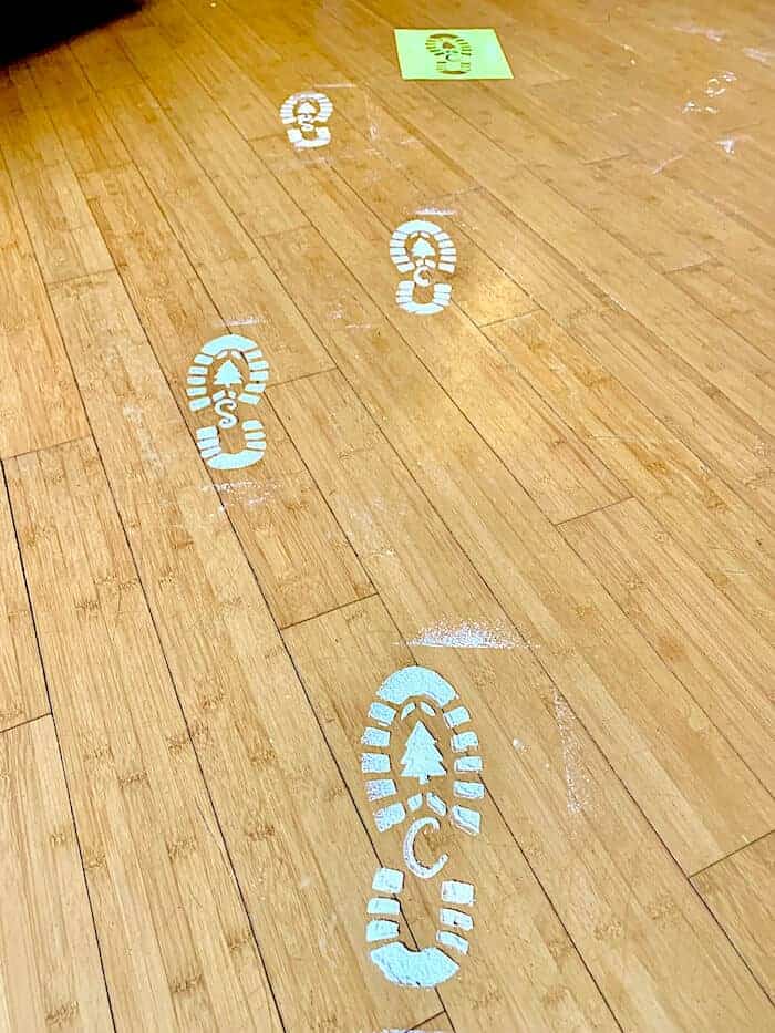 line of faux Santa Claus footprints across a wood floor