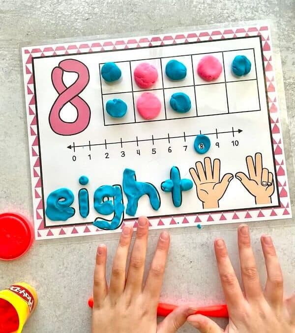 child playing with number playdough mat