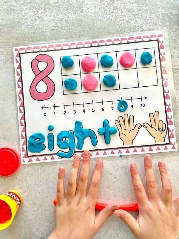 child playing with number playdough mat