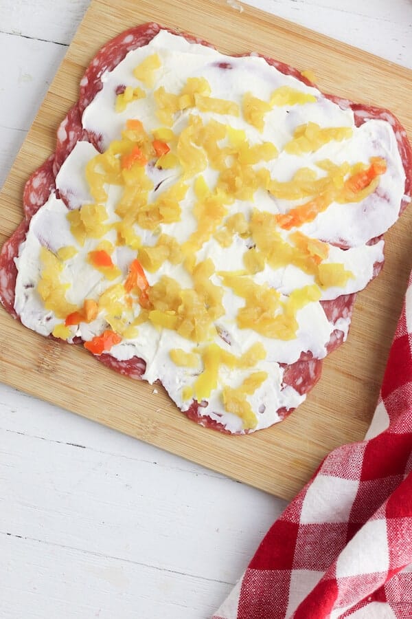cream cheese and banana peppers on top of salami slices