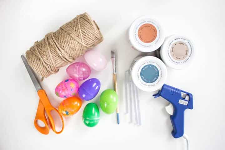 twine, plastic eggs, hot glue gun, scissors, and paint