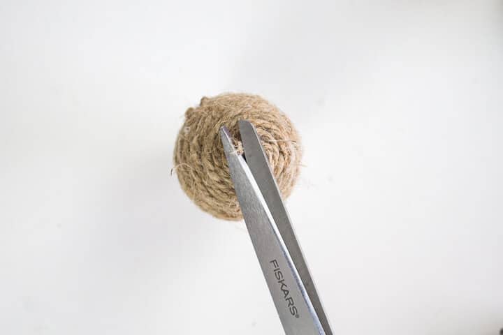 cutting the end of twine on a wrapped plastic egg