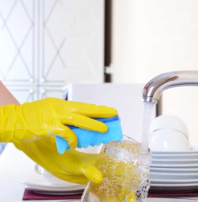 woman washing dishes at kitchen sink