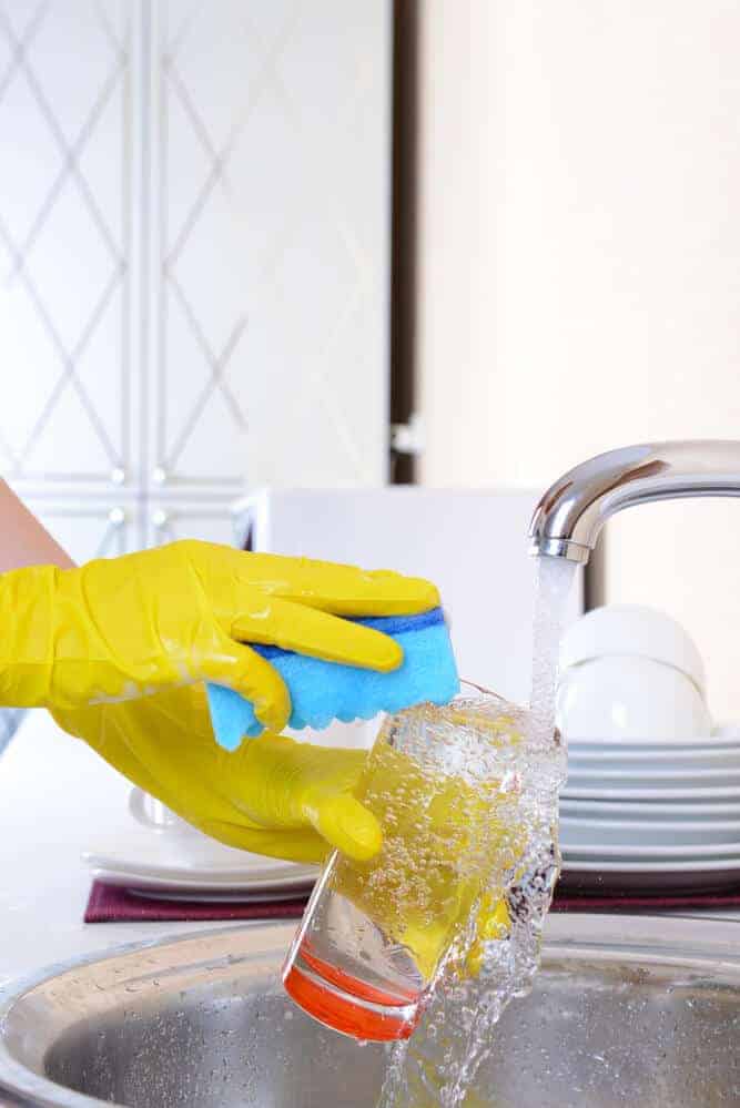 woman washing dishes at kitchen sink