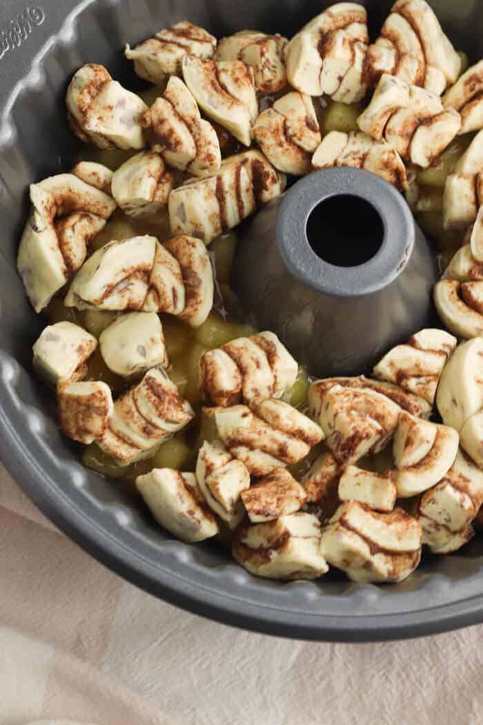 apple pie filling and cinnamon roll dough in a bundt pan