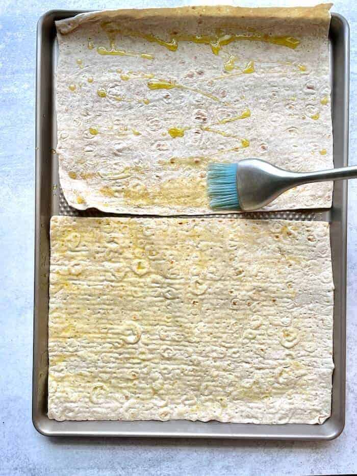 brushing olive oil on a flatbread