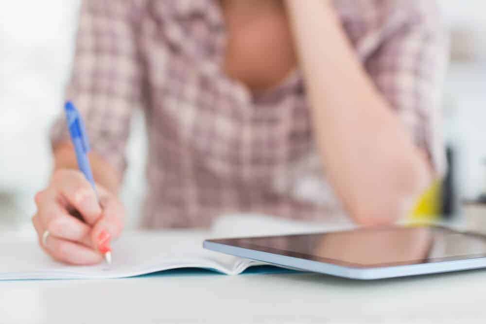 woman writing in a weekly planner